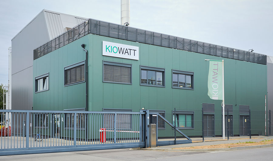 A building with green siding and a sign "Kiowatt" in capital letters can be seen.