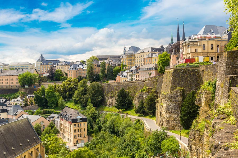 A slope with the UNESCO monument from the city of Luxembourg to see. Many shades of yellow, green and brown create a harmonious image of the city.