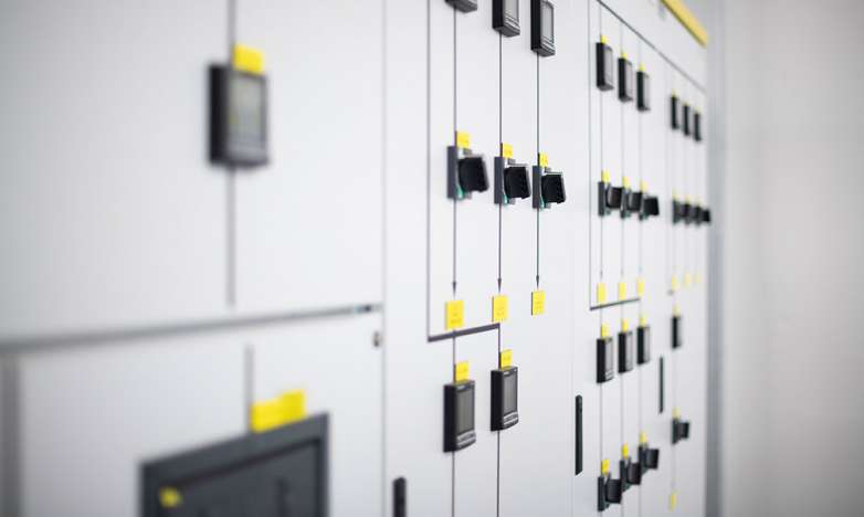 Power management systems for data centers are on display. These have a white front with yellow markings and black switches.